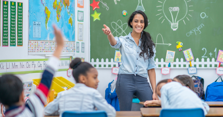 A female teacher standing in a classroom in front of a group of students